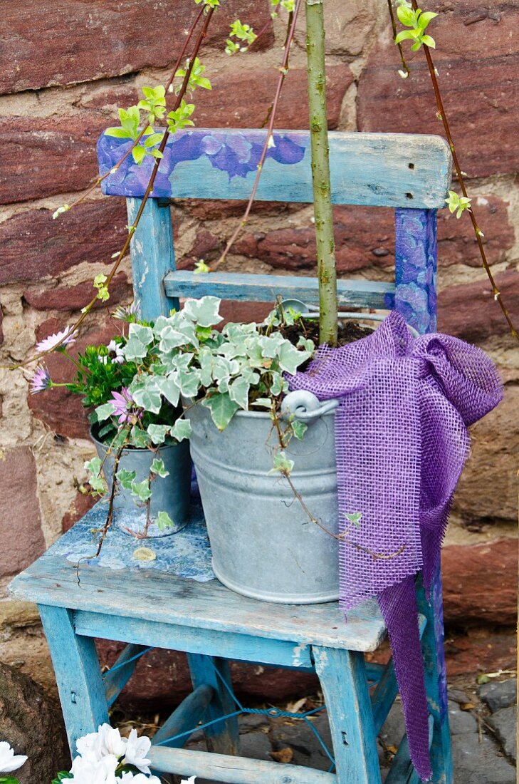 Blue chair with plants in a galvanized bucket