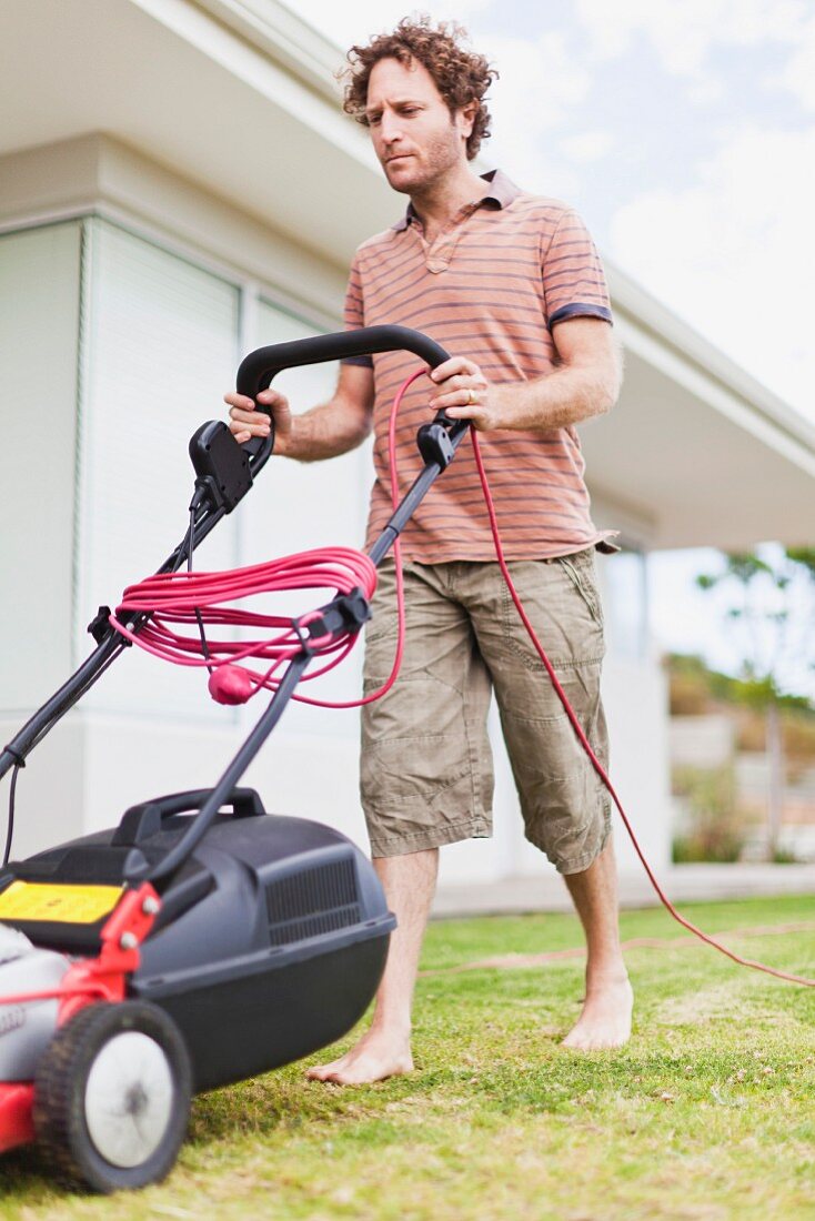 Man mowing lawn in front of house