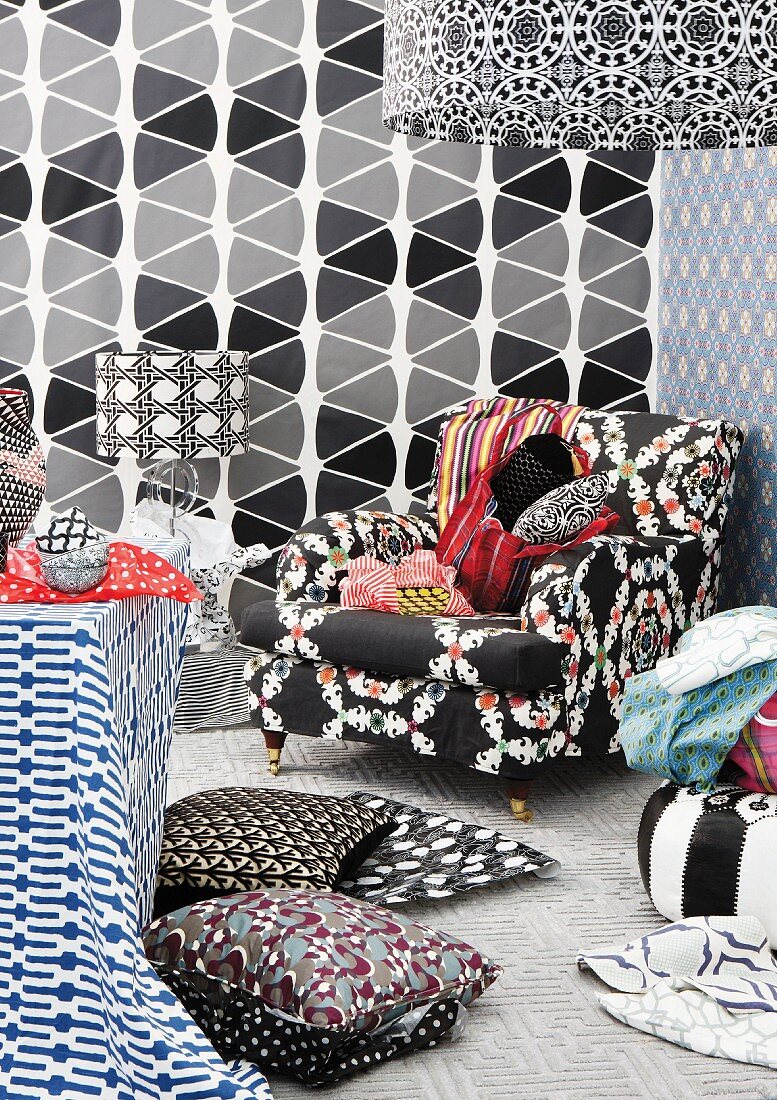 Mixture of patterns on lampshades, wallpaper, cushion covers and armchair upholstery