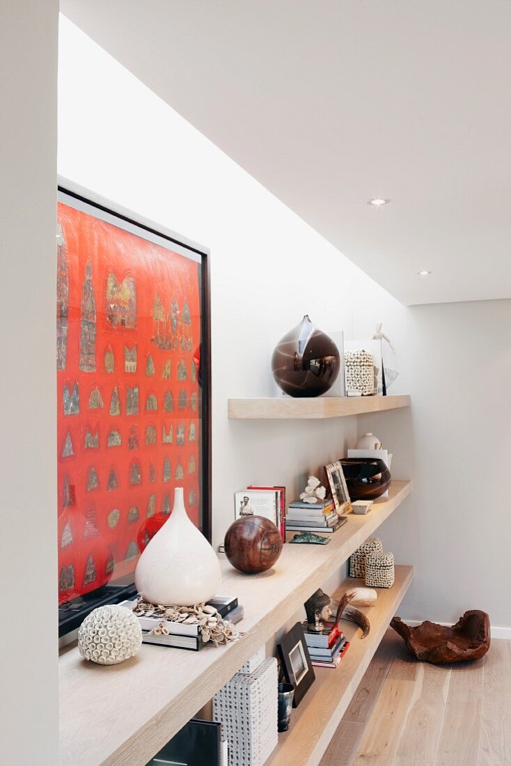 Collection of objets d'art and ornaments on floating shelves lit from above
