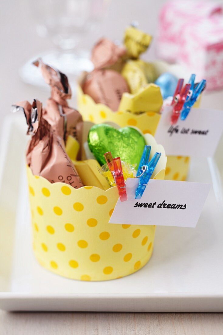 Papierförmchen mit Süßigkeiten & verziert mit Zetteln & kleinen Klammern