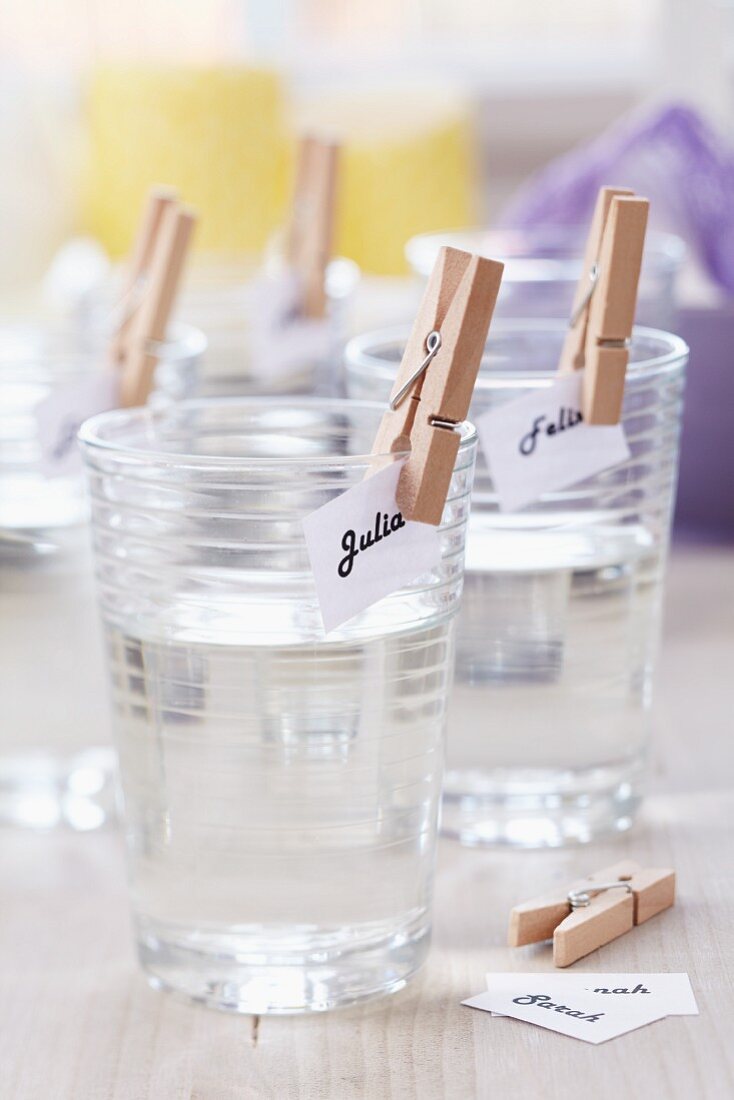 Name tags attached to drinking glasses with clothes pegs