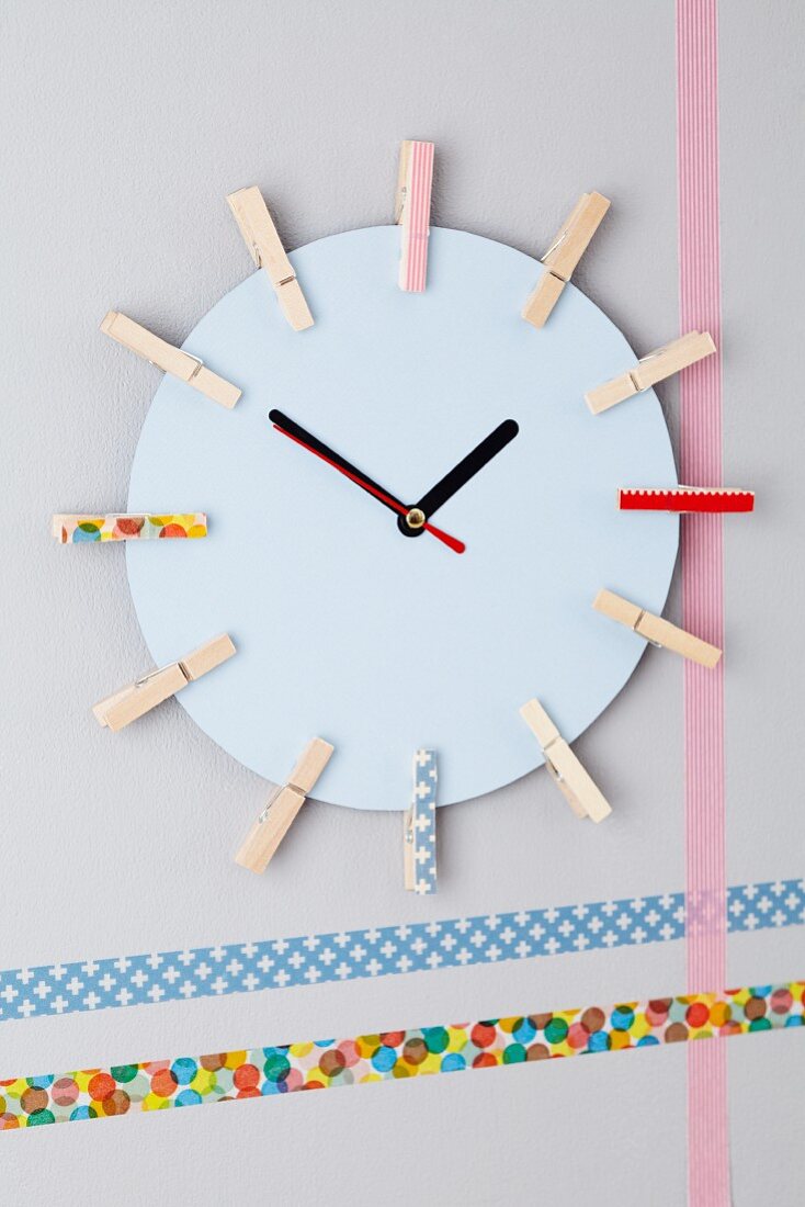 Wall clock made from cardboard and clothes pegs