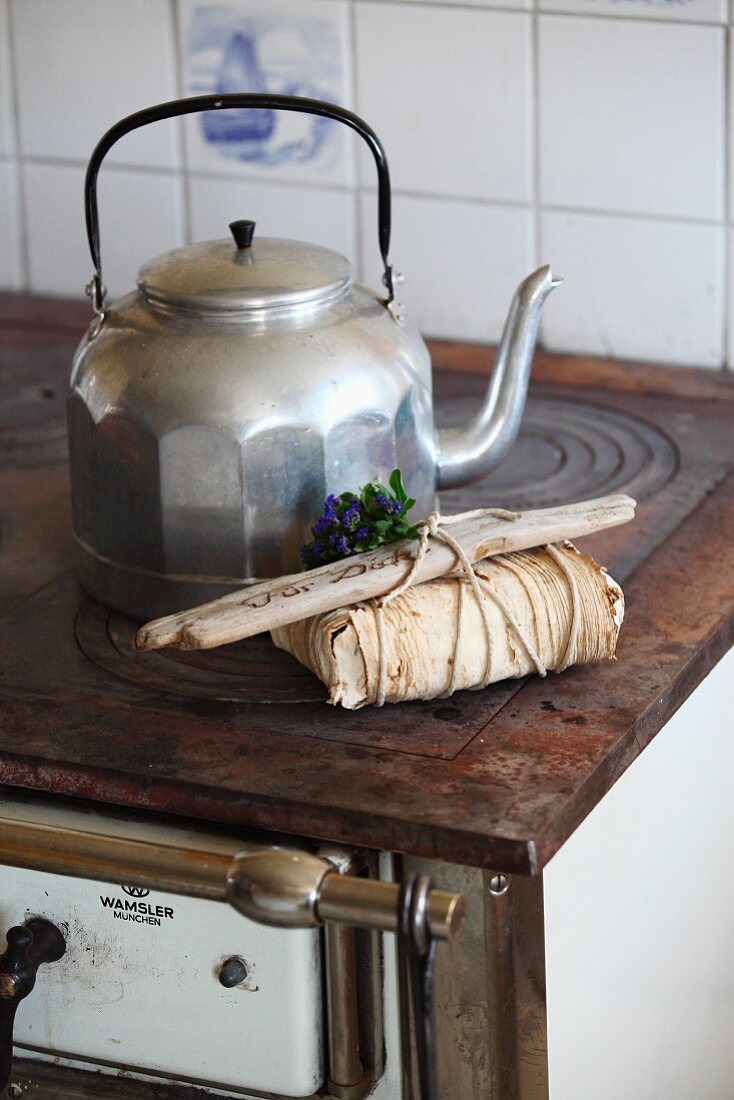 Lovingly wrapped gift decorated with driftwood and forget-me-nots on nostalgic cooker