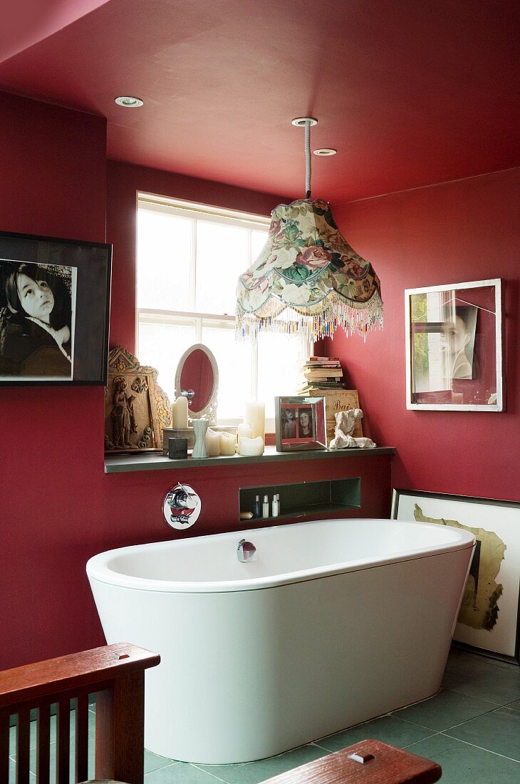 Free-standing bathtub in red-painted bathroom