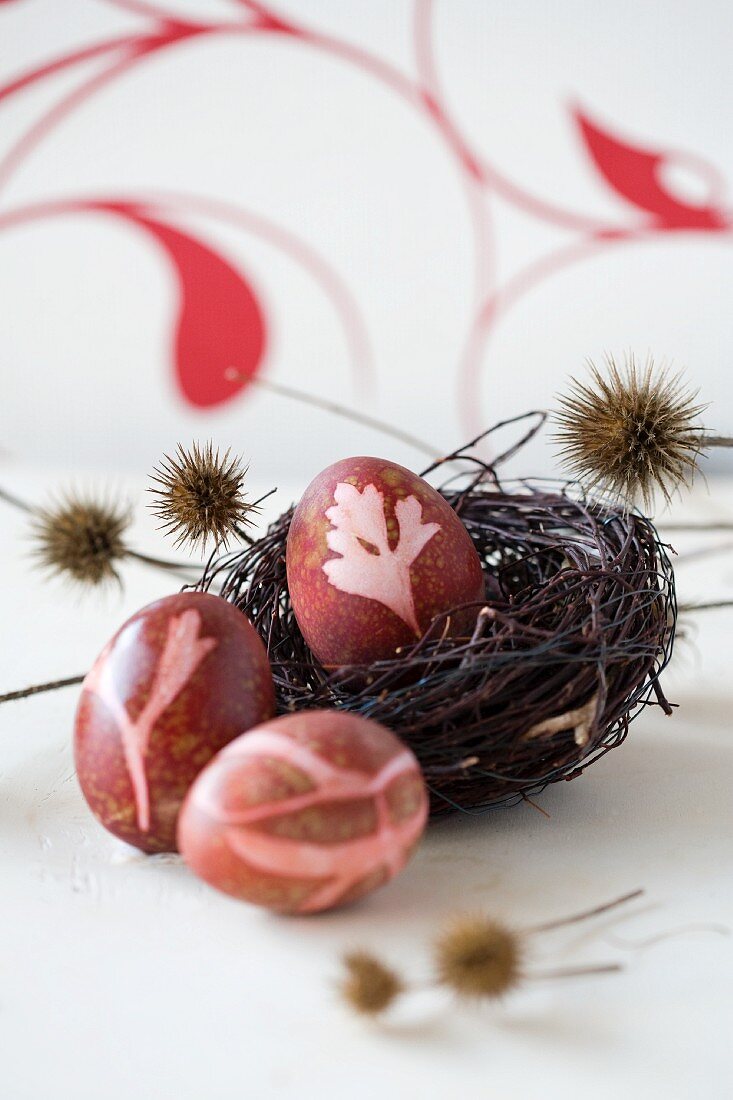 Three Easter eggs colored with natural dyes (red beet)
