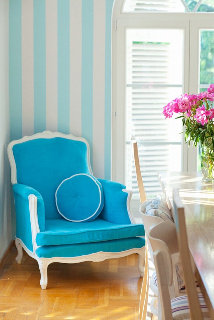 Blue antique armchair next to an arched window
