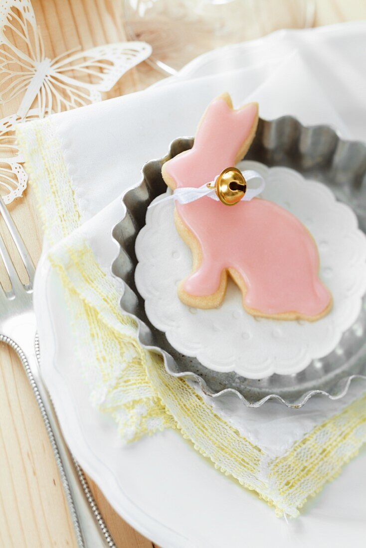 Keks in Hasenform mit rosa Zuckerguss und kleinem Glöckchen in Tortelettform