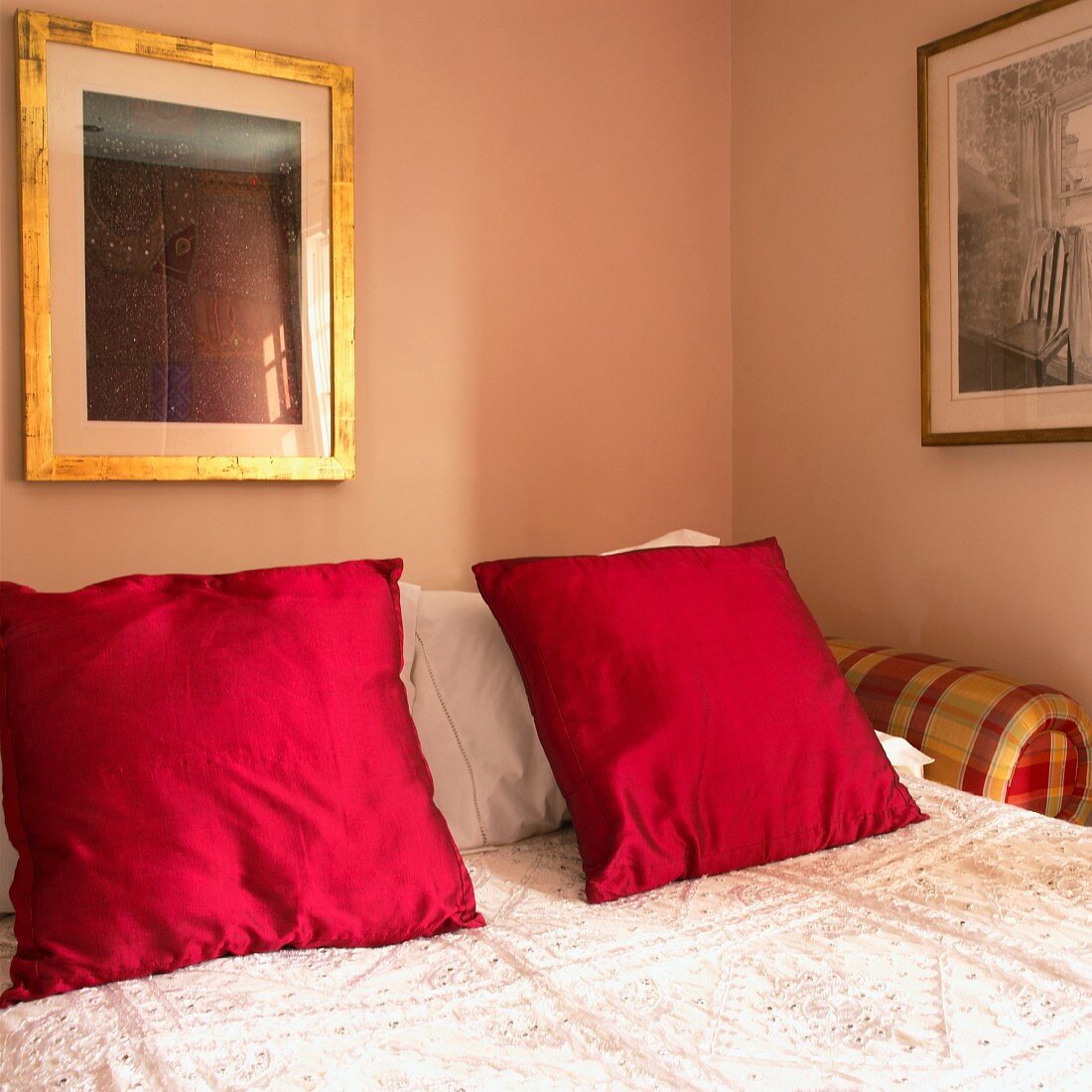 Double bed with red pillows and bedspread (close up)