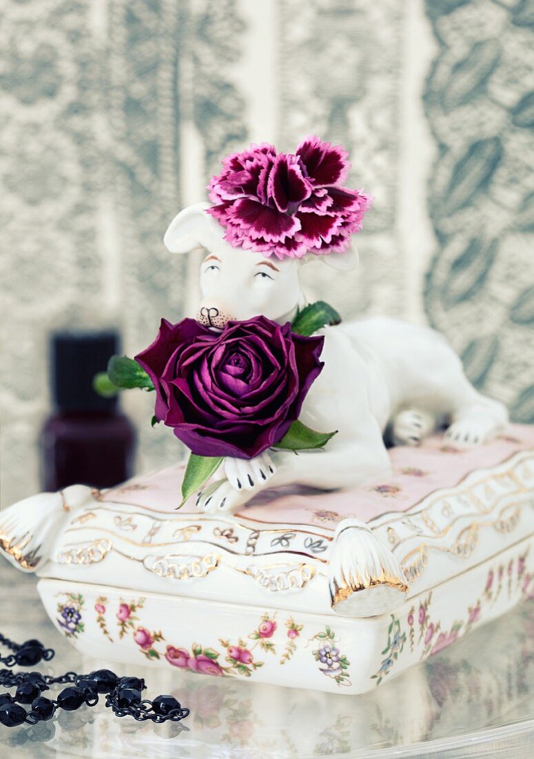 Purple floribunda rose & purple carnation on antique china casket topped with dog figurine