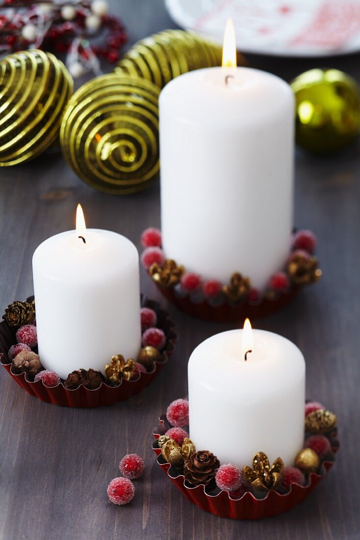 Pillar candles and Christmas decorations in small tart tins