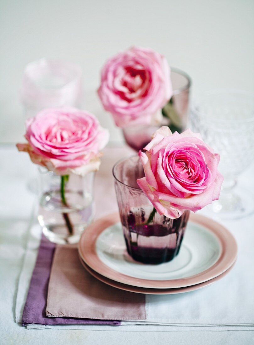 Pink roses in glasses decorating table