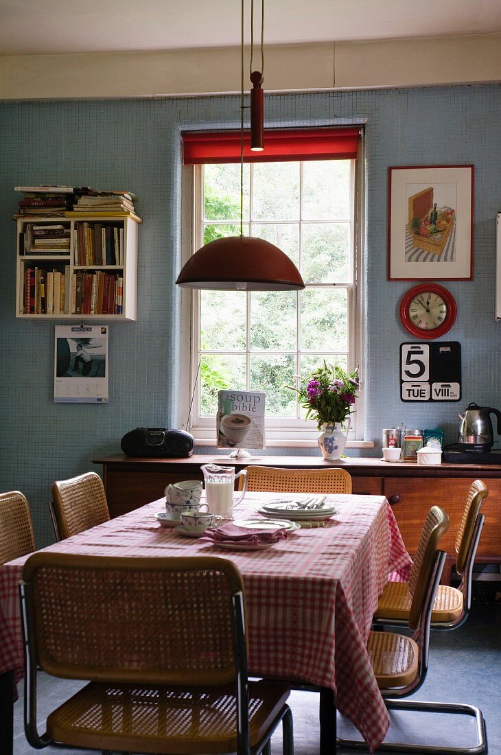 Vintage-Küche mit blauen Wänden, roten Farbakzenten und Essplatz mit Freischwingerstühlen aus den Sixties