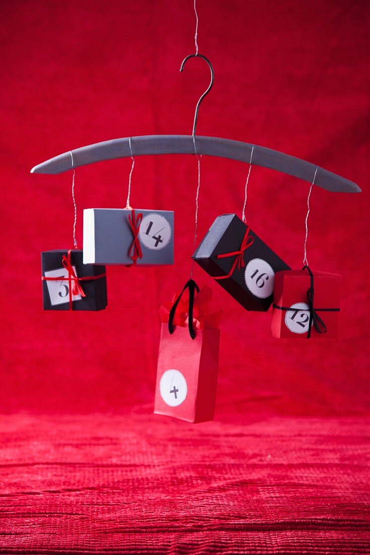 Hand-crafted advent calendar of small paper boxes strung on coat hanger