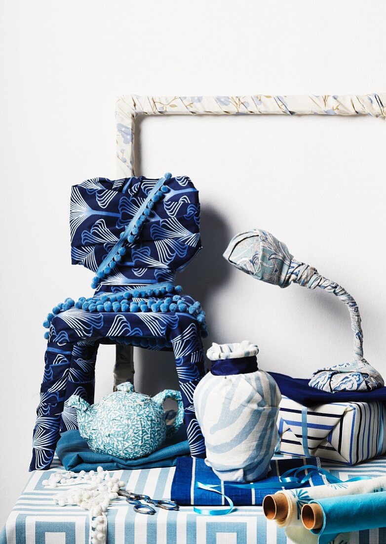 Various, every-day objects wrapped in blue and white fabrics and recognisable by their shapes