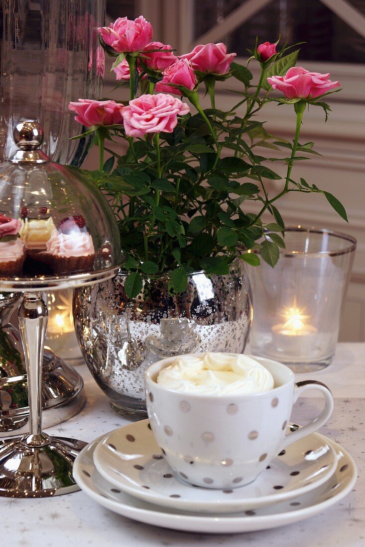 Gedeckter Tisch mit Kaffeegedeck, Gebäck & Blumen