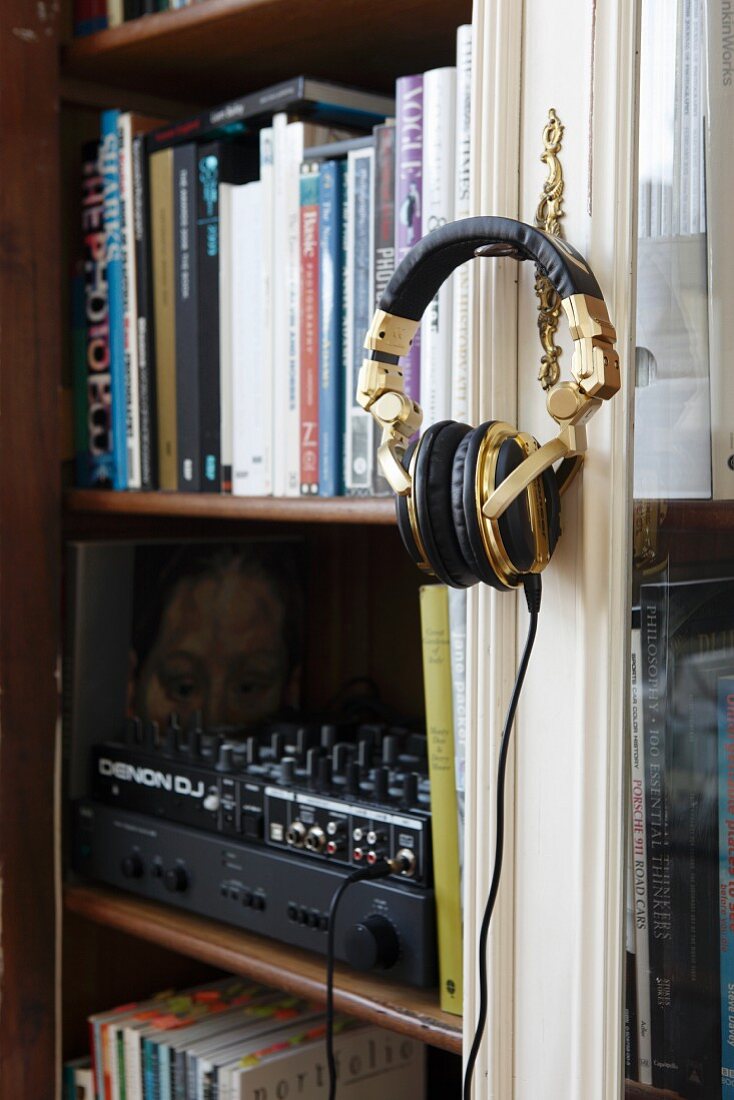Books and hifi in glass-fronted cabinet; headphones hanging on cabinet key