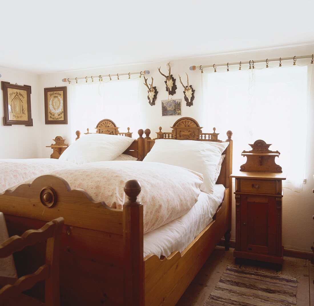 Bäuerliches Schlafzimmer mit geschnitztem Mobiliar und Jagdtrophäen