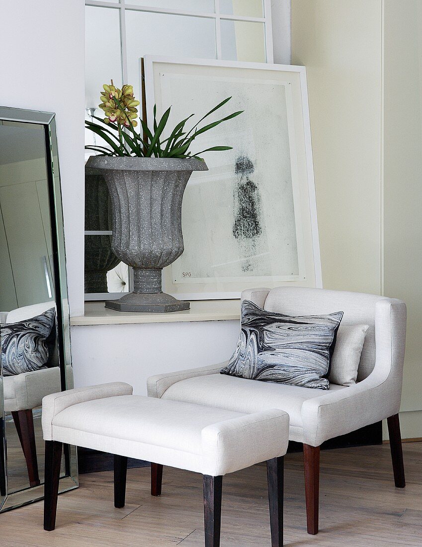 Sessel mit Fussschemel im Art Deco Stil vor Fenster mit Bild & pokalartigem Pflanzgefäss auf Fensterbank