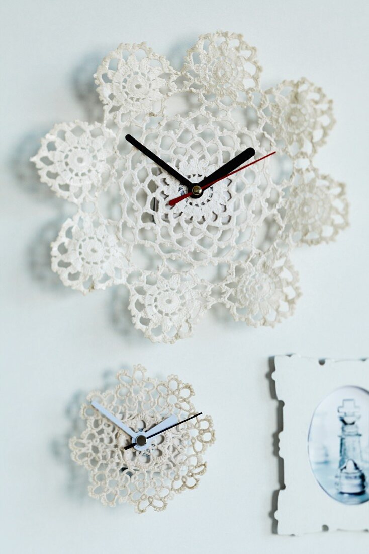 Wall clocks with faces made from stiffened crocheted doilies