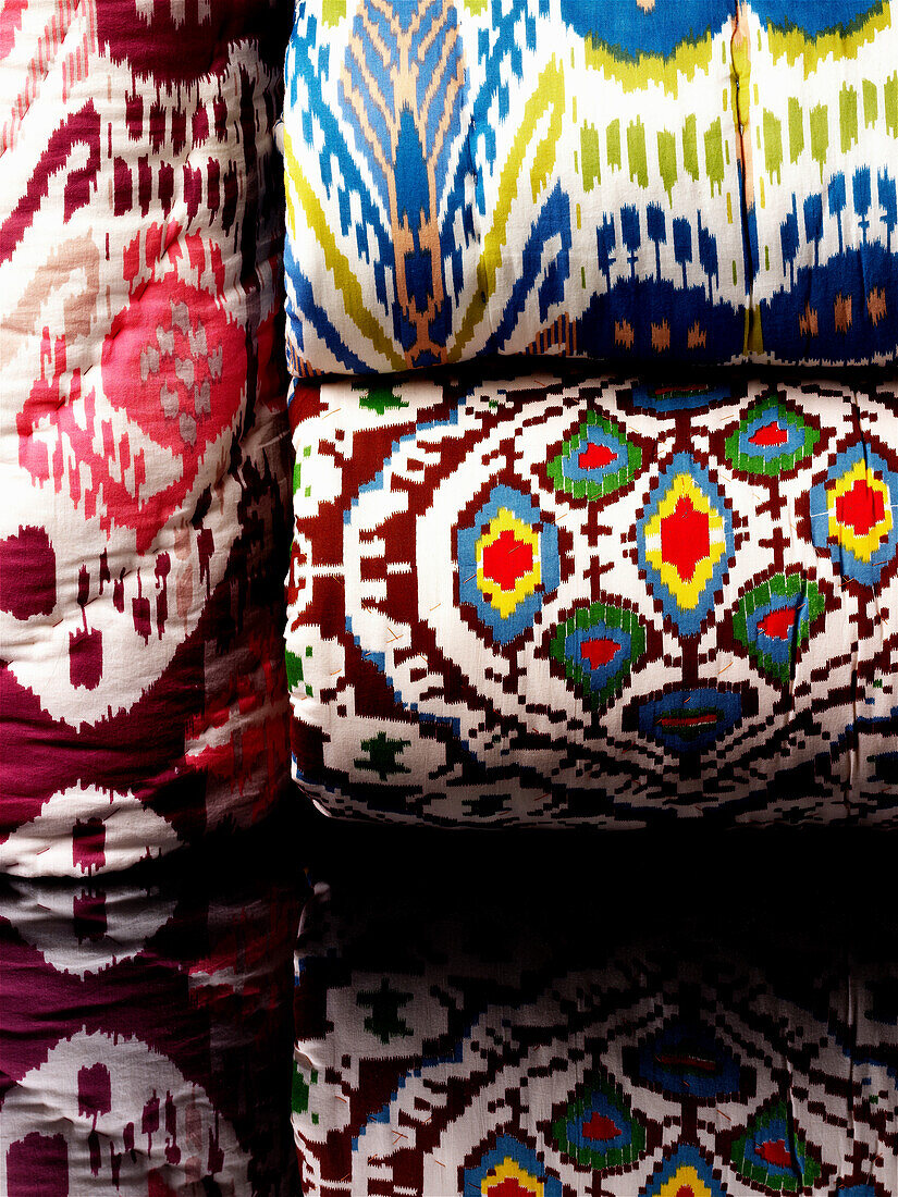 Rolled up blankets in a colourful mix of patterns