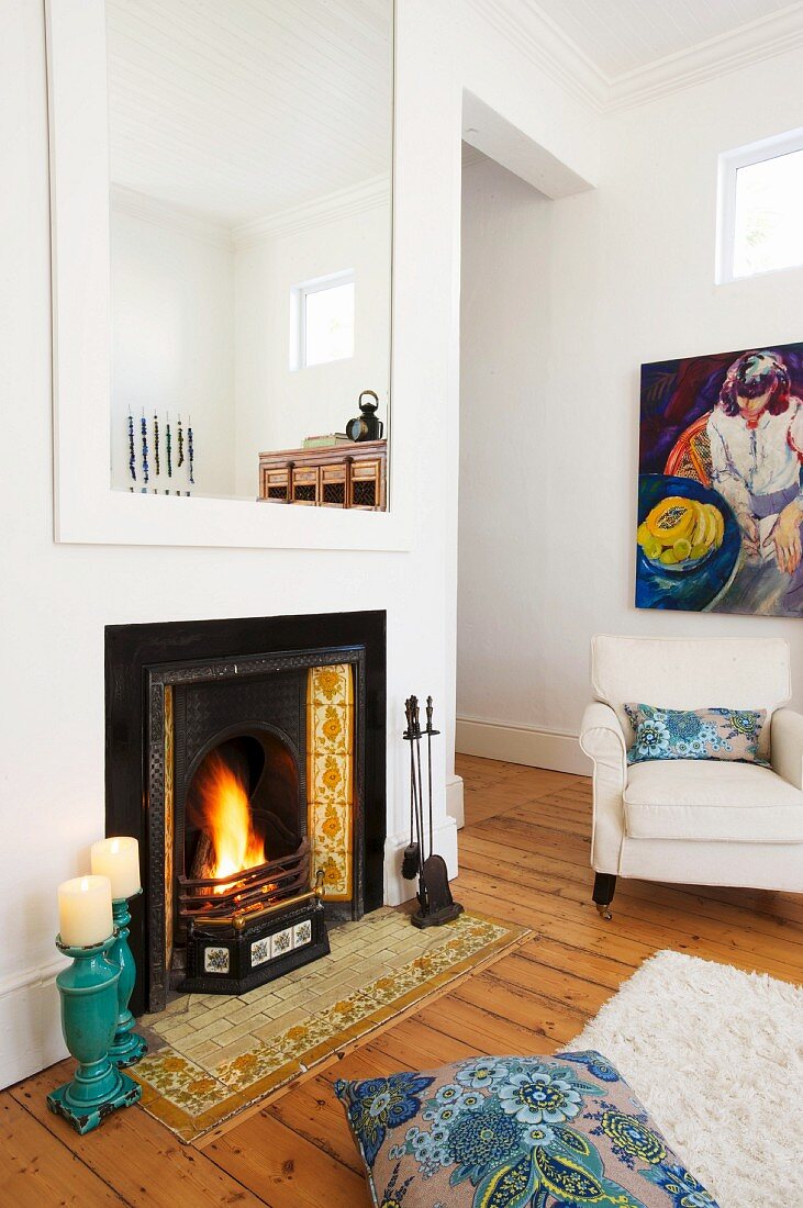 Offener Kamin mit Wandspiegel & Sessel in minimalistischem Wohnraum mit traditionellem Flair