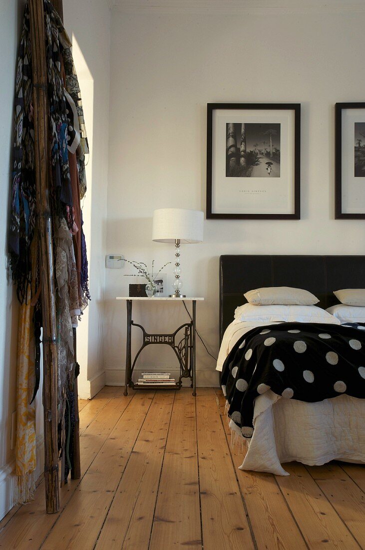 Double bed with black and white polka dot bedspread in rustic bedroom