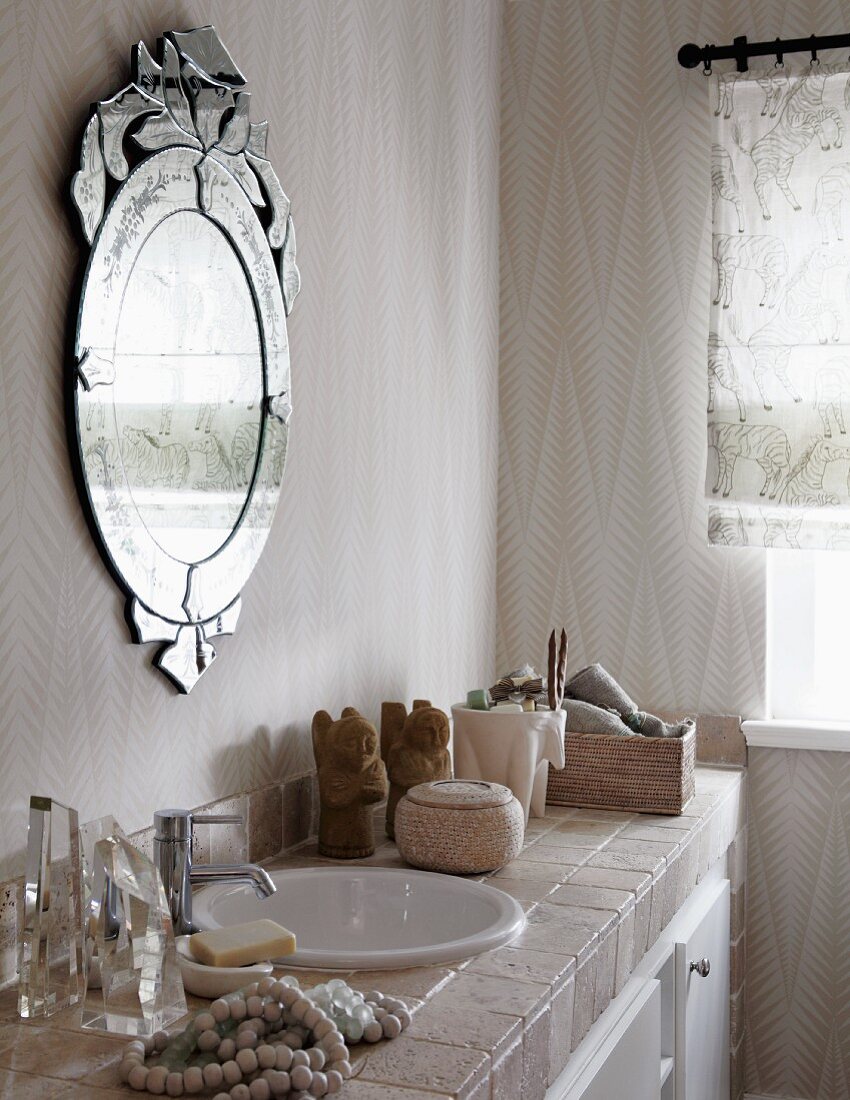 Ornate mirror on wall above toiletries on tiled washstand