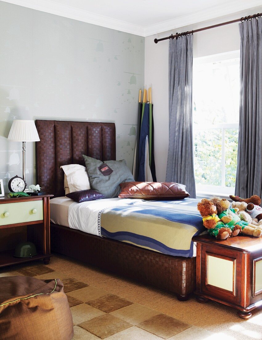Elegantes Herrenschlafzimmer mit braunem Bett mit gepolstertem Kopfteil
