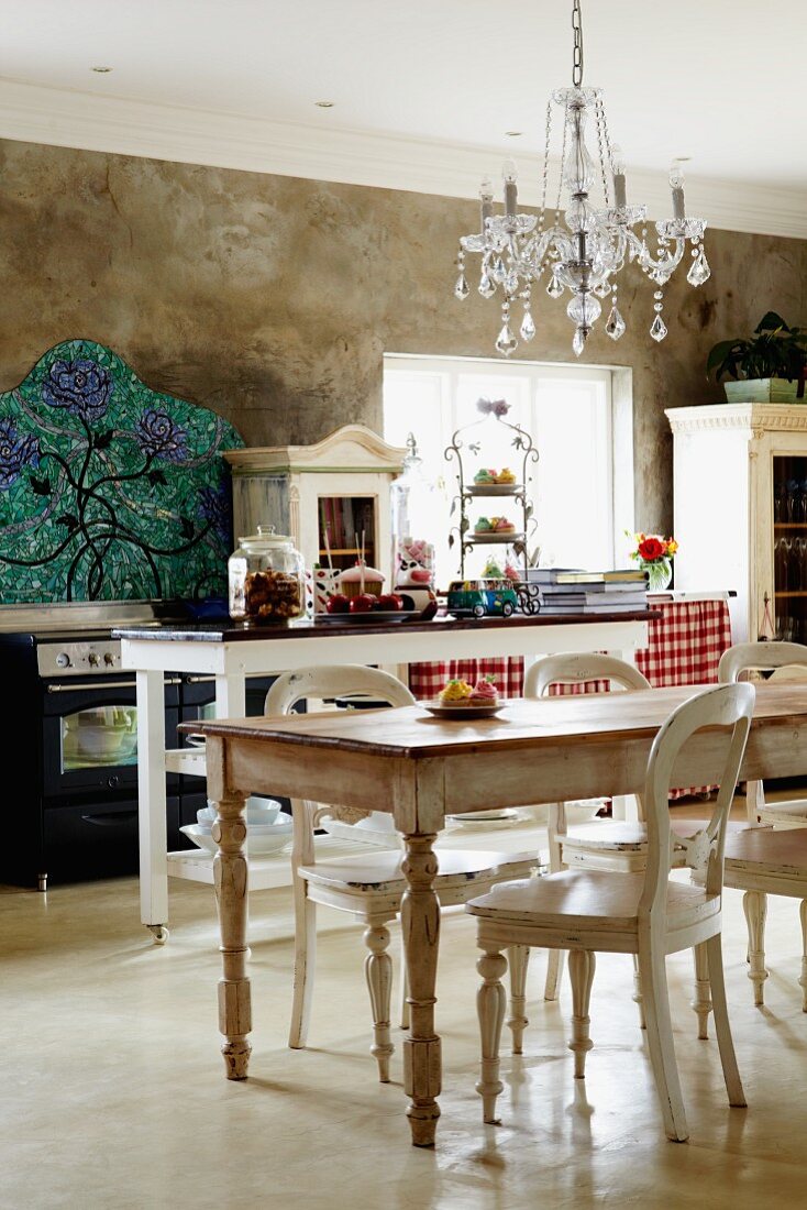 Küche im Landhausstil mit Shabby-Esstisch und Stühlen unter Kronleuchter