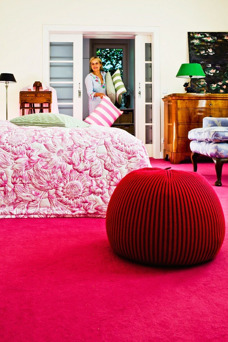 Pouf aus Merinowolle auf pinkfarbenem Teppich in Schlafzimmer