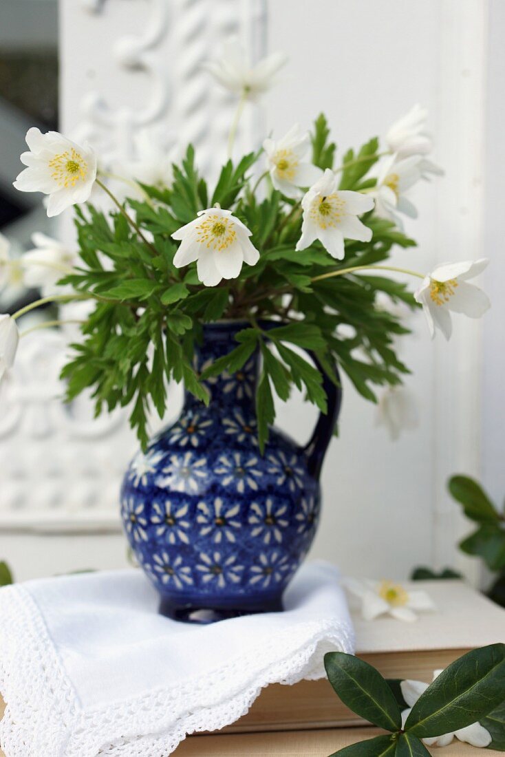 White anemones in blue ceramic jug