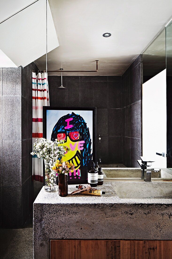 Waschtisch aus Beton mit Holzfront vor Spiegelwand in zeitgenössischem Bad mit grauen Wandfliesen