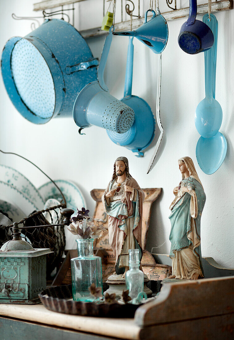 Vintage-Dekoration mit religiösen Figuren und blauen Küchenutensilien