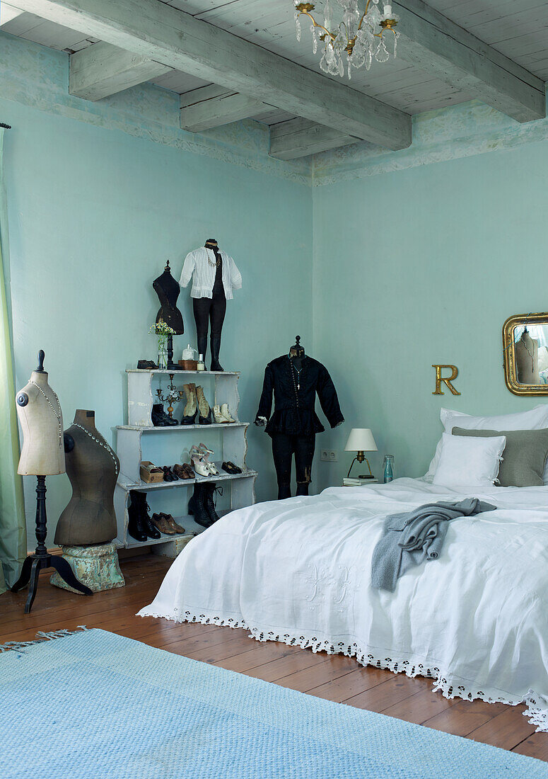 Bedroom with vintage dressmaker's dummies and bed linen in white