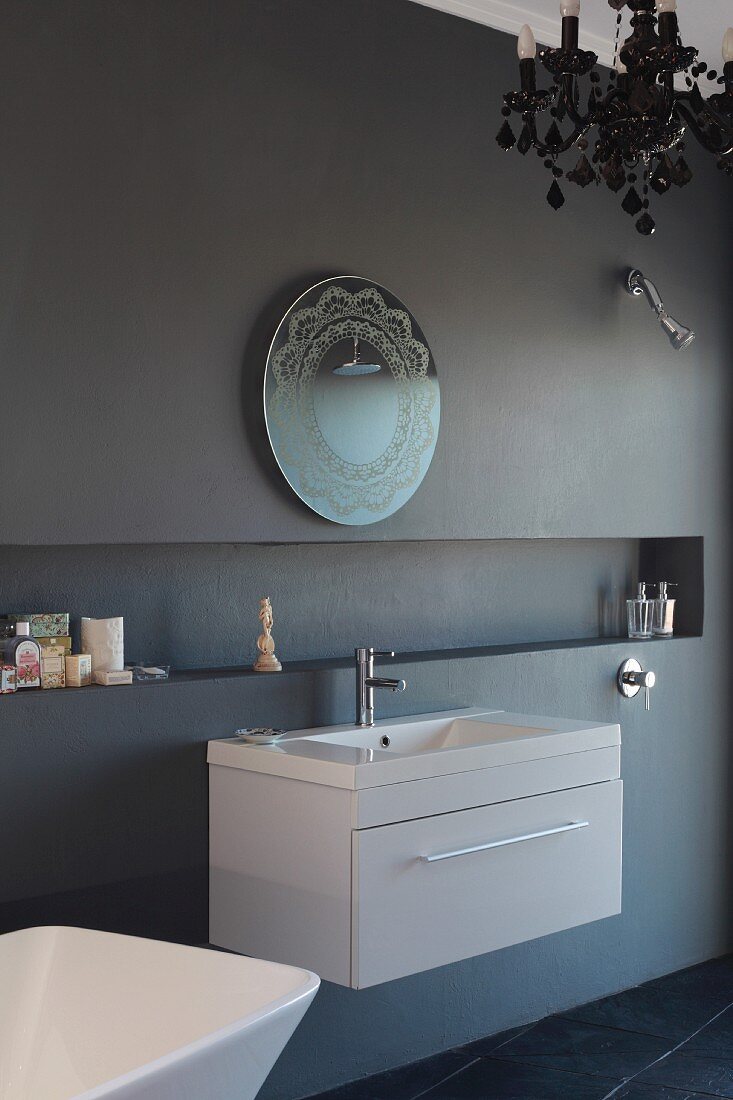 Ornate mirror and modern washstand on anthracite wall with long, narrow niche