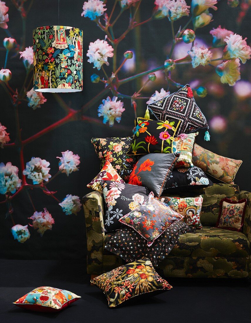 Colourful scatter cushions on armchair against floral wallpaper