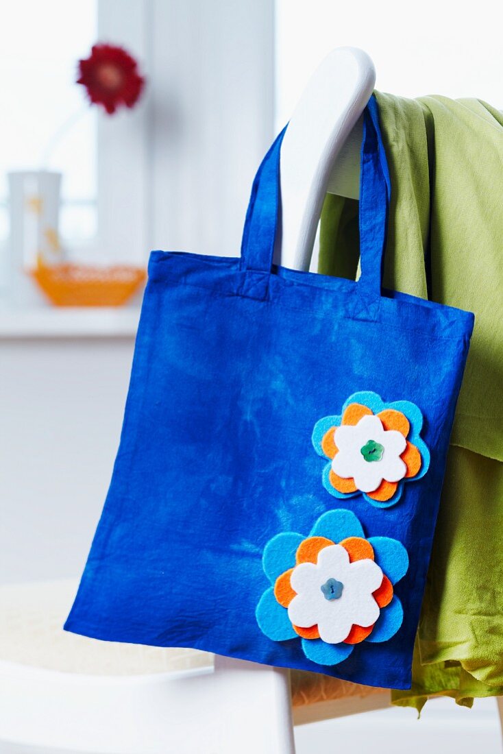 Blaue Stofftasche mit aufgenähten Filz-Blüten