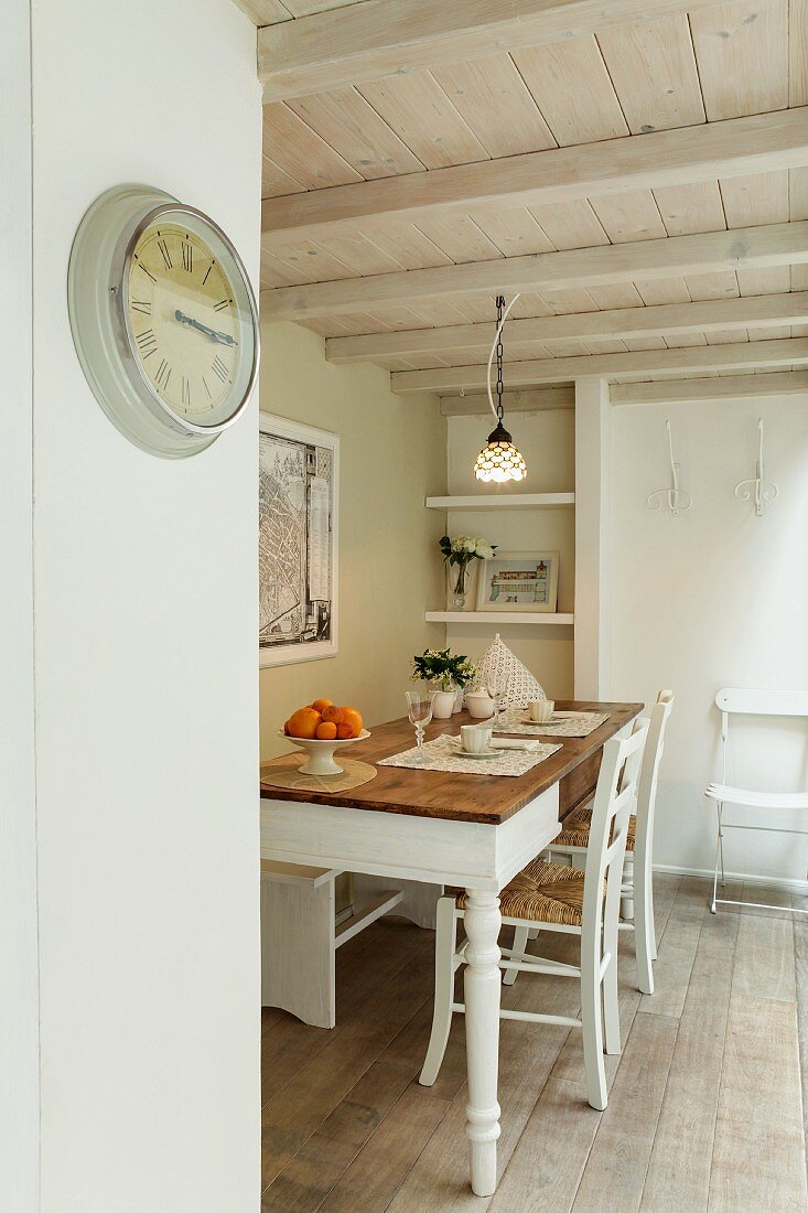 Dining area in rustic ambiance with wooden ceiling and simple, vintage clock