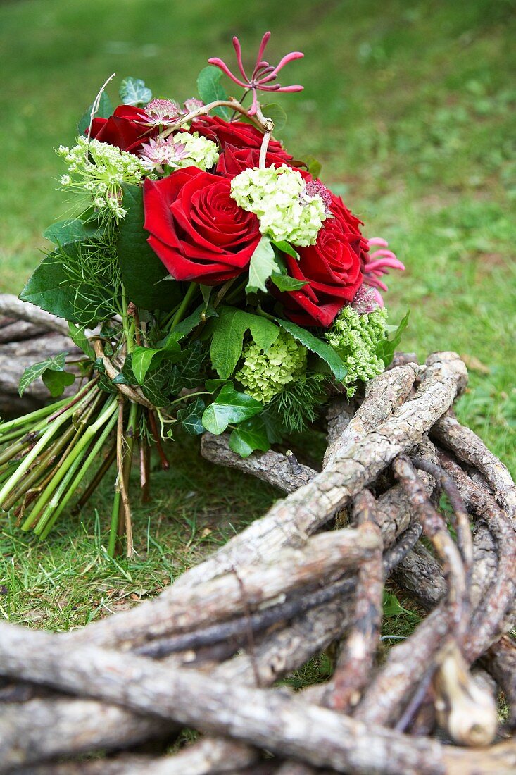 Blumenstrauß mit roten Rosen auf Zweigen