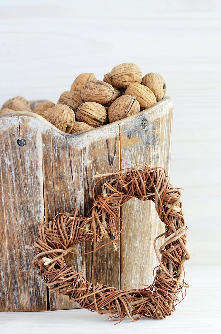 Walnuts in wooden basket and wicker heart
