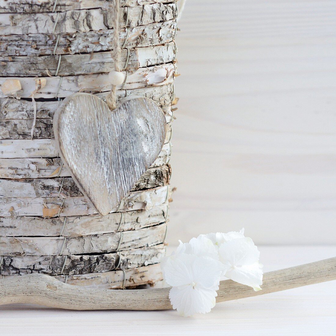 Wooden heart hanging on stack of birch discs