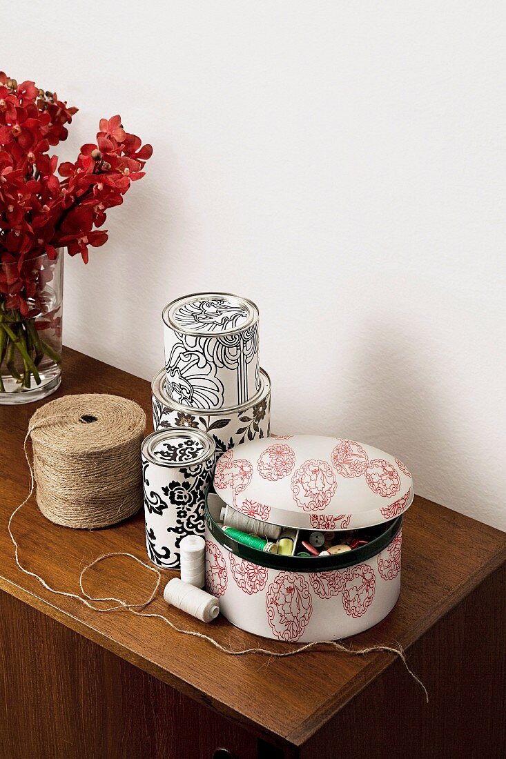 Floral boxes and spools of string on sideboard