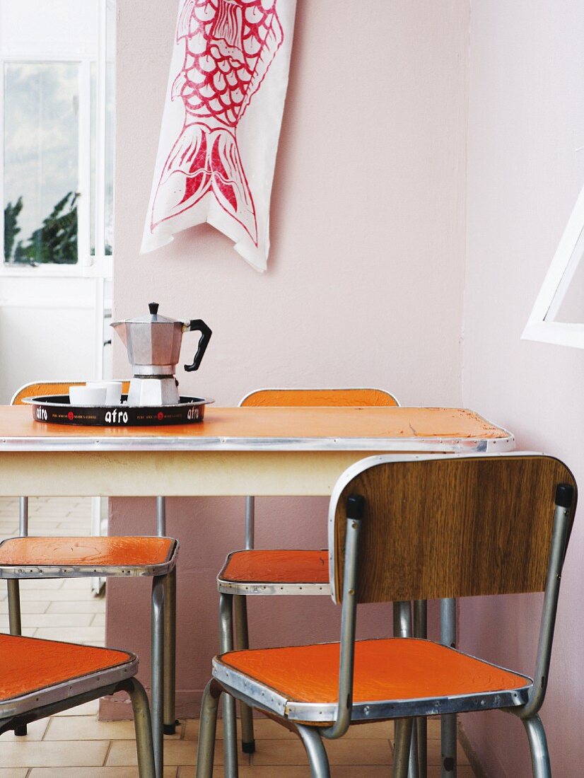 Original, 60's, vintage dining set with orange, plastic surfaces and espresso pot on breakfast tray on table