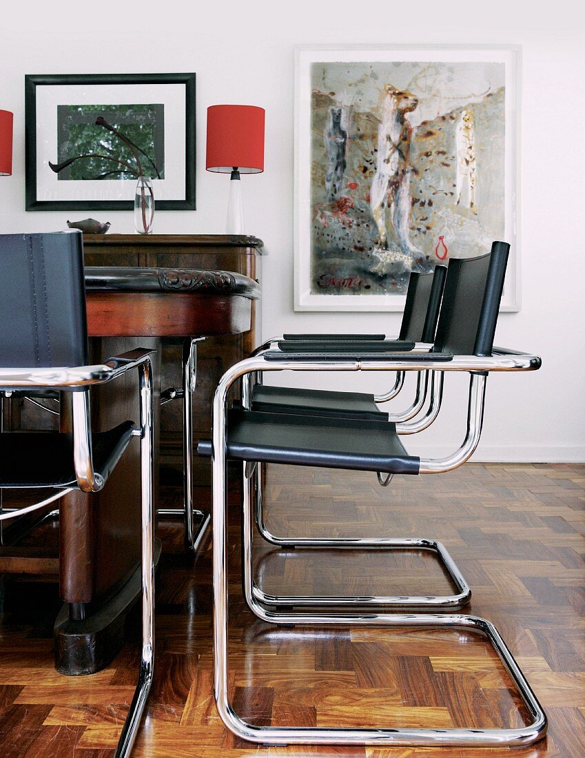Bauhaus Freischwinger mit schwarzem Lederbezug vor antikem Tisch in traditionellem Wohnzimmer