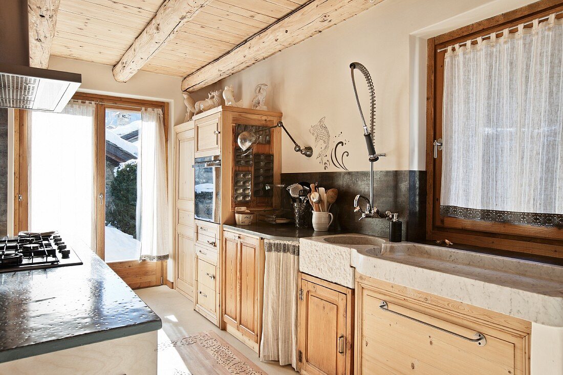 Open-plan kitchen with rustic kitchen counter & solid wood base units