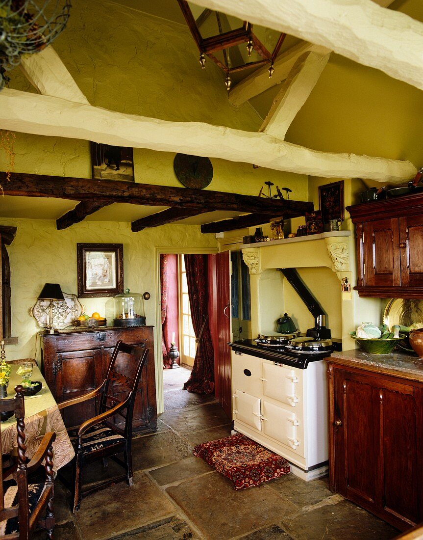 Landhausküche mit gelben Wänden, Holzschränken & Steinboden