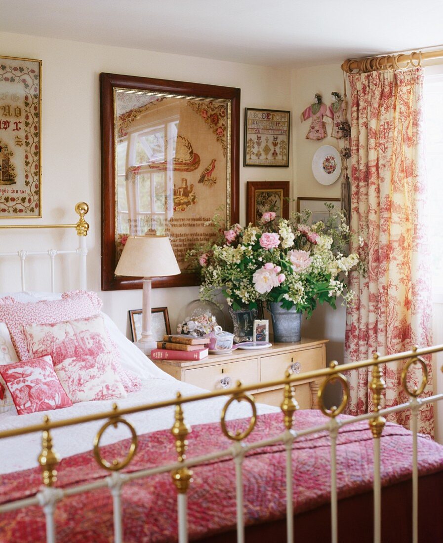 Schlafzimmer mit Kommode, Messing-Bett & Vorhänge und Kissen mit Toile de Jouy-Mustern