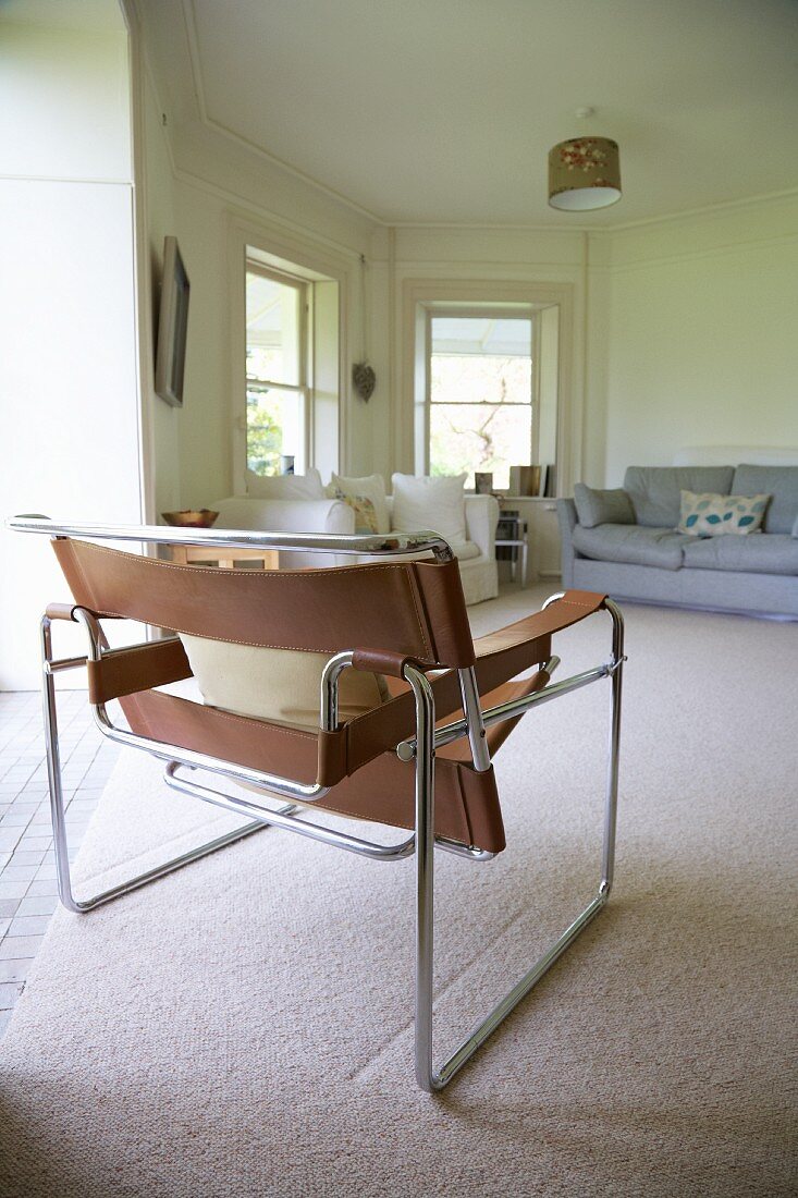Mehreckiges Wohnzimmer mit Sofas & Metallstuhl mit Lederbezug