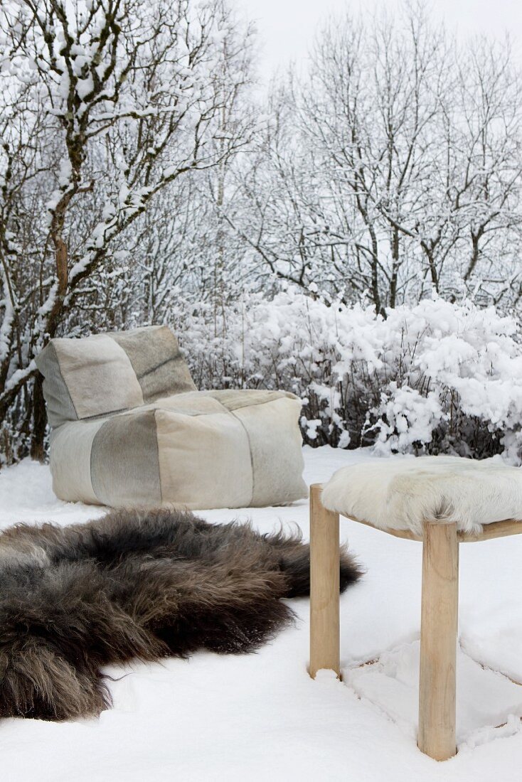 Sitzsack, Fellteppich und Hocker mit Fellbezug im Schnee